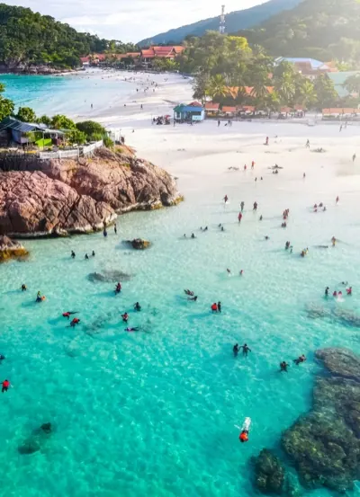 Swimmers in clear shallow water off a beach